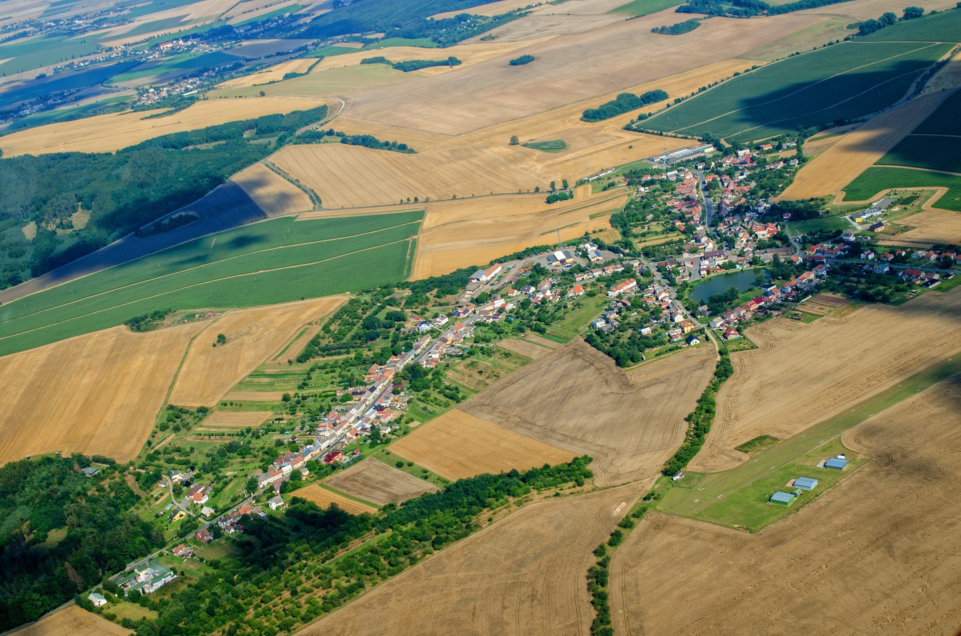 Luftbild mit Dorf und Ackerflächen