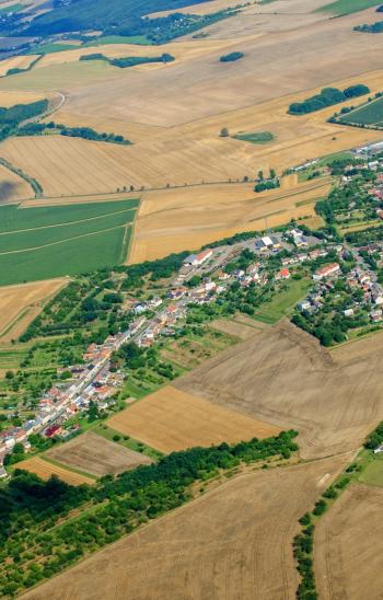 Luftbild mit Dorf und Ackerflächen